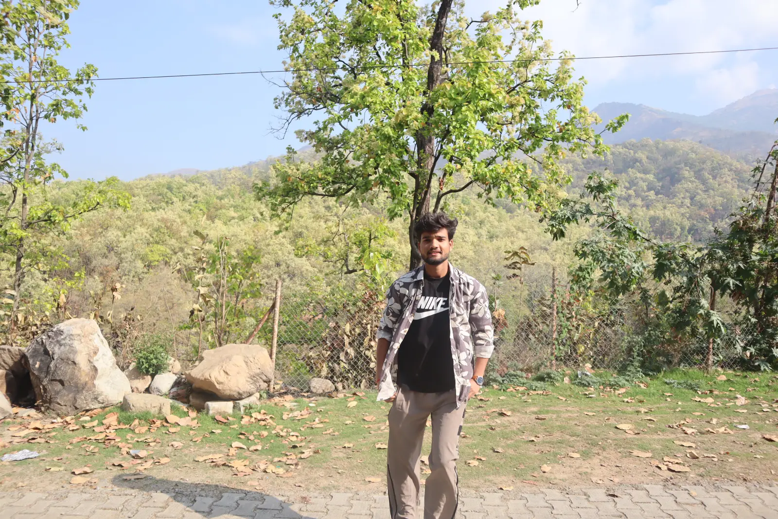 Asit Kumar outdoors among the trees and hills